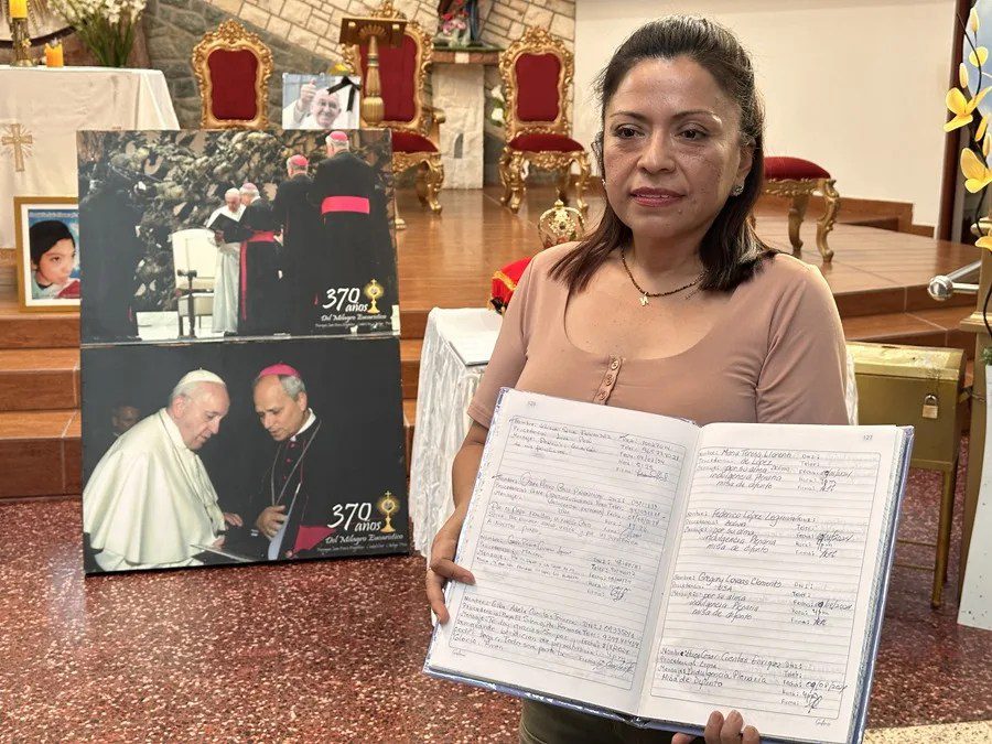 Noemi Ñiquen, integrante de la parroquia Santa María Magdalena, sostiene unos cuadernos con testimonios de fe hechos por visitantes a la parroquia este viernes, en Eten, provincia de Chiclayo (Perú). EFE/ Mikhail Huacan