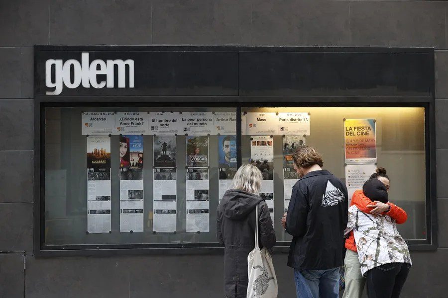 Espectadores observan la cartelera de los Cines Golem