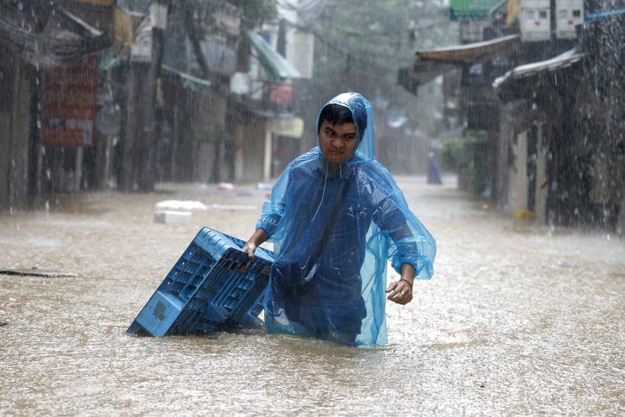 Un hombre camina a través de las aguas inundadas en Hanoi, Vietnam